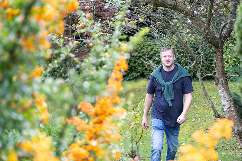 Männercoach Josef Mayer geht in einem Garten