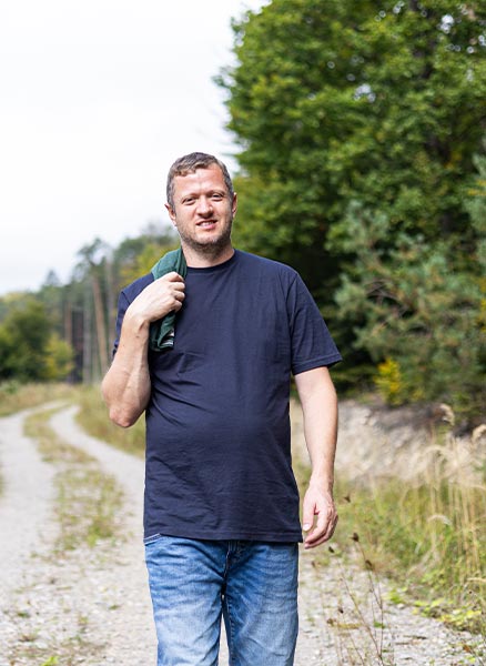 Coach Josef Mayer geht auf einem Feldweg